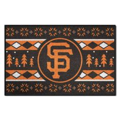 the san francisco giants door mat with an orange and black design on it, surrounded by pine trees