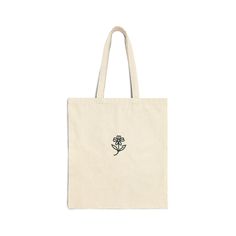 Tote bag made of 100% cotton with a black flower design. It is made of a strong, sturdy fabric perfect for everyday use. Flower-shaped Cotton Shoulder Bag For Everyday Use, Flower Shaped Cotton Shoulder Bag For Everyday Use, Cotton Flower-shaped Shoulder Bag For Everyday Use, Everyday Cotton Flower-shaped Shoulder Bag, Casual Cotton Flower-shaped Bag, Everyday Cotton Shoulder Bag With Floral Print, Floral Print Cotton Shoulder Bag, Cotton Flower-shaped Bag For Daily Use, Floral Shaped Cotton Gift Bag