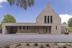 a large brick house sitting on top of a gravel field