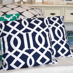 two pillows sitting on top of a bed with blue and white designs in them,