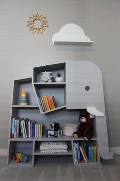 an elephant shaped book shelf with books and toys on it's shelves in a child's room