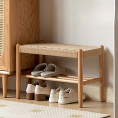 two pairs of shoes are sitting on the floor next to a wooden bench and cabinet