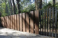 a wooden fence in front of some trees