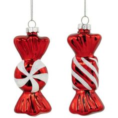 two red and white christmas ornaments hanging from silver chains, one with a candy cane in it's mouth