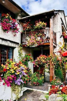 a building with flowers growing all over it and the words spring written in large green letters