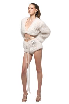 a woman in white fur coat and shorts