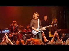 a group of people that are standing in front of a microphone and some guitar players