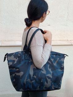 Handmade Camo Leather Tote Bag. Versatile and Stylish Handbag for Every Occasion. Introducing our Boston Bag. A luxurious and spacious leather tote that seamlessly combines functionality with high fashion. This tote is expertly handcrafted in our Barcelona atelier from premium calf leather, featuring a striking grey, blue, and black camouflage design that adds a unique touch to any outfit. Perfect for Every Day and Beyond. This camo leather tote is designed to complement any style, making it the perfect choice for work, shopping, travel, or a day out. Its unique blend of practicality and fashion ensures it will become a staple in your wardrobe. FEATURES: Premium Materials: Made with high-quality calf leather in a distinctive camouflage pattern, this tote is both durable and stylish. Versat Large Capacity Coated Canvas Bag For Outdoor, Functional Camouflage Bags For Everyday Use, Camouflage Bag With Adjustable Strap For Everyday Use, Camouflage Functional Travel Bags, Functional Camouflage Travel Bag, Camouflage Travel Bag With Adjustable Strap, Casual Camouflage Bags For Everyday Use, Casual Camouflage Shoulder Bag For Everyday Use, Casual Camouflage Shoulder Bag For Travel