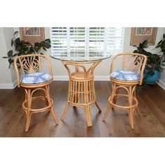 two wicker bar stools and a round glass top table with blue cushioning