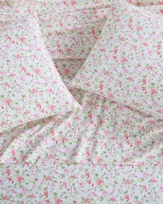 pink and green flowers on white sheets with matching pillow cases in the corner, close up