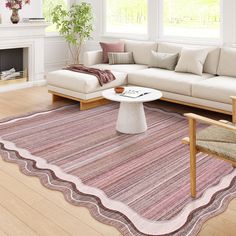 a living room filled with furniture and a large rug on top of a hard wood floor