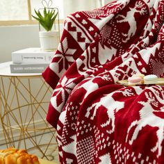 a red and white blanket sitting on top of a bed next to a table with food