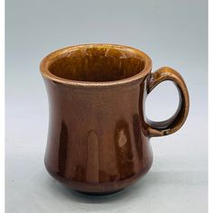 a brown cup sitting on top of a white table