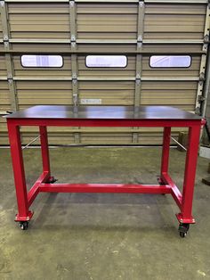 a red table sitting in front of a garage door