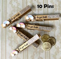 some gold and silver colored pins with words on them next to two pennets that say, i've got 10 pins