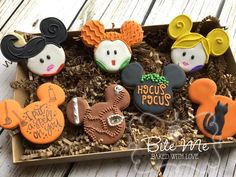 mickey mouse cookies in a box on a wooden table with the words hocus pocus