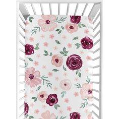 a white crib with pink flowers and green leaves on the bottom, in front of a white background