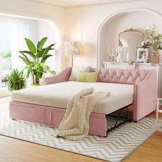 a living room with a pink couch and white rug