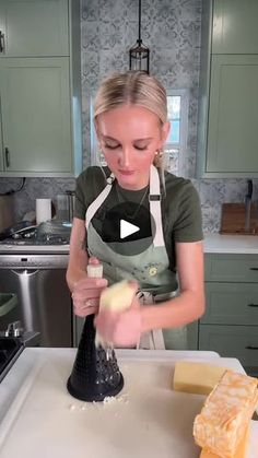 a woman in an apron is making cheese