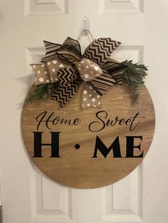 a wooden sign that says home sweet home with bows on the front and side of it