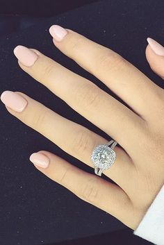 a woman's hand with a diamond ring on it