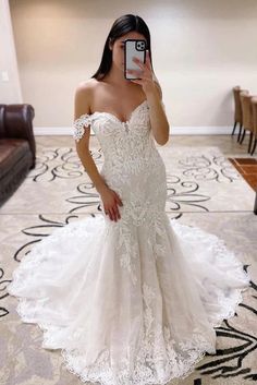 a woman is taking a selfie in her wedding dress while standing on the floor