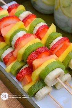 fruit skewers are arranged on a plate