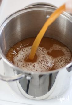 a metal pot filled with liquid on top of a stove