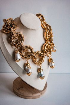 A stunning statement piece unfolds with our Chunky Rope Chain Necklace, adorned with five exquisite Baroque Pearl Pendants enclosed in intricately crafted gold-plated twirls. Each pearl, showcasing its unique natural beauty, adds an element of grace and allure to this exceptional necklace. The chunky rope style chain not only enhances durability but also elevates the necklace to a bold fashion statement. Perfect for both everyday elegance and special occasions, this necklace is a must-have addit Unique Gold Baroque Pearl Necklaces, Unique Gold Necklace With Baroque Pearl, Elegant Rope Chain Jewelry, Luxury Gold Baroque Necklace, Unique Gold Jewelry With Baroque Pearl, Elegant Twisted Gold Chain Necklace, Gold Baroque Necklace For Parties, Exquisite Gold Baroque Jewelry, Elegant Twisted Gold Jewelry