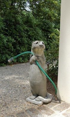 a statue of an alligator holding a hose