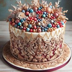 there is a cake decorated with colorful decorations on the top and bottom layer, as well as gold trimmings