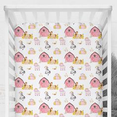 a white crib with pink farm animals on it