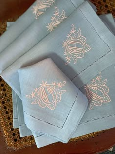 four linen napkins with gold designs on them