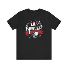 ⚾ Capture the excitement of baseball with our “LA Paparazzi” T-Shirt! This tee features a unique and eye-catching design of the fictional LA Paparazzi baseball team, perfect for fans of the sport. Made from soft, high-quality fabric, it ensures comfort and style for any casual occasion. Whether you’re watching the game or out and about, this shirt is a hit! 🌟 This classic unisex jersey short sleeve tee fits like a well-loved favorite. Soft cotton and quality print make users fall in love with it over and over again. These t-shirts have-ribbed knit collars to bolster shaping. The shoulders are tapered for a better fit over time. Dual side seams hold the garment's shape for longer. .: Made with 100% Airlume combed and ring-spun cotton, a lightweight fabric (4.2 oz/yd² (142 g/m²)) that is ea Baseball Team, Lightweight Fabric, Black Tee, The Game, Fall In Love, Graphic Tee, Ribbed Knit, Quality Fabric, Short Sleeve Tee