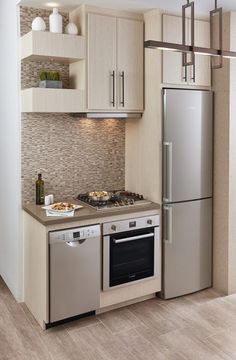 a modern kitchen with stainless steel appliances and wood flooring is pictured in this image