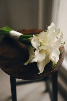 a bouquet of white flowers sitting on top of a wooden table