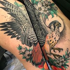 a woman's thigh with an eagle and flowers on it