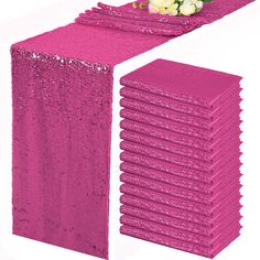 pink sequin table runners with flowers on each side and white roses in the center