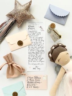 an assortment of items including a doll, envelope and star on a white table top