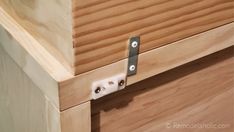 a close up of a wooden drawer with two metal latches