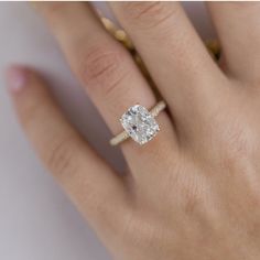 a woman's hand with a diamond ring on top of her finger and an engagement band