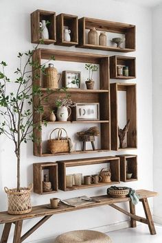 a wooden shelf filled with lots of shelves next to a table and potted plant