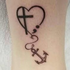 a cross and an anchor tattoo on the ankle that says love is in the air