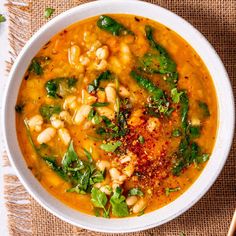 a white bowl filled with beans and greens