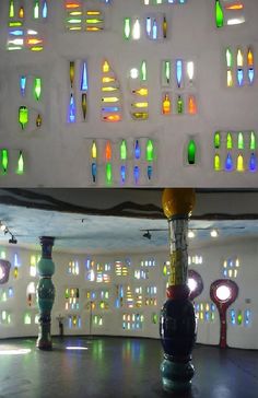 a room filled with lots of different colored glass bottles hanging from the ceiling next to each other