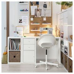 a white desk and chair in a room with lots of storage space on the wall