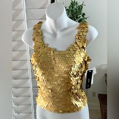 New Rimini By Shaw Gold Sequin Sleeveless Top Mermaid Style Size Small Nwt Fully Lined In New Condition The Gold Color Is A Matte. Does Stretch A Bit But Not Much As Each Sequin Is Sewn On. There Is A Hidden Zipper In The Back. Very Sexy Top! Pit To Pit Is 16” Length Is 19” This Is An Amazing Fun Tee Top! All Items Are Stored In A Non-Smoking Environment. Thank You For Shopping My Closet. I Hope You Come Again As I Add New Items Every Week! Happy To Consider Reasonable Offers. Bundle 2 Or More Items For Greater Savings! Clubbing Party Resort Gala Holiday Festive Derby Stored In A Non Smoking Environment 1 Sequin Halter Top, Evening Blouses, Party Blouse, Mermaid Style, Lace Camisole, Sequin Tank Tops, Puff Sleeve Blouse, Sleeveless Crop Top, Mermaid Fashion