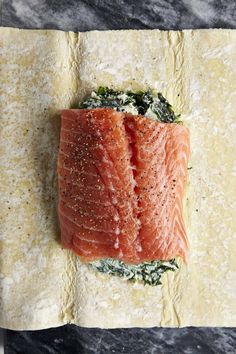 a piece of raw salmon sitting on top of a cutting board