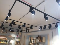 some lights are hanging from the ceiling in a room with shelving and other items