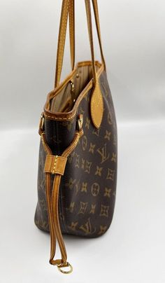 The Neverfull PM tote pairs timeless design with heritage details. Crafted from the classic LV monogram canvas with natural cowhide trim, it is capacious yet not bulky, with side laces that cinch for a sleek allure or loosen for a casual look. Slim, comfortable handles slip easily over the arm. The Louis Vuitton monogram is a print that is carefully crafted from durable, brown canvas, Louis Vuitton's embossed, classic interwoven "LV" has remained the brand's signature since 1896. Louis Vuitton’s Elegant Monogram Canvas Bag For Daily Use, Elegant Monogram Canvas Bags For Daily Use, Elegant Bag With Removable Pouch In Monogram Canvas, Monogram Canvas Pouch Bag With Handles, Elegant Monogram Canvas Bag With Removable Pouch, Elegant Monogram Canvas Bags With Removable Pouch, Classic Monogram Canvas Bag For Shopping, Classic Coated Canvas Bags With Gold-tone Hardware, Classic Coated Canvas Shoulder Bag